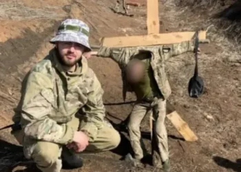 Фото УП. Владислав Пастух фотографується на тлі прив'язаного до хреста військового